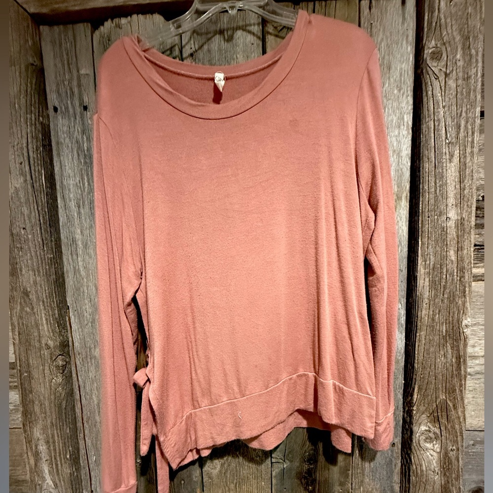 Blush pink long sleeve shirt ties on the side.